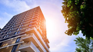 Çok katlı, modern bir apartmanın dış cephesi, pencereleri ve balkonları..