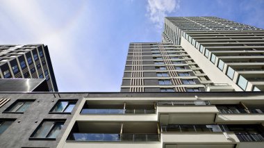 Çok katlı, modern bir apartmanın dış cephesi, pencereleri ve balkonları..