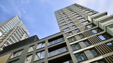 Çok katlı, modern bir apartmanın dış cephesi, pencereleri ve balkonları..