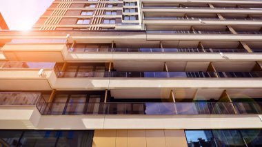 Çok katlı, modern bir apartmanın dış cephesi, pencereleri ve balkonları..