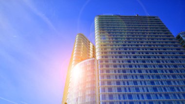Güneşin uzun, modern bir binanın cam cephesindeki yansıması. İşletme inşaat endüstrisi ve emlak finansmanı. Güneşli şehir manzarası. 