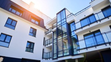 Modern apartman binası. Konut mimarisine yenilikçi bir yaklaşım. Gökyüzünde gün ışığı parlıyor.