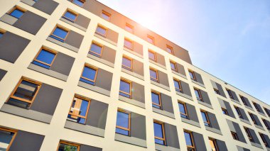 Modern apartman binası. Konut mimarisine yenilikçi bir yaklaşım. Gökyüzünde gün ışığı parlıyor.