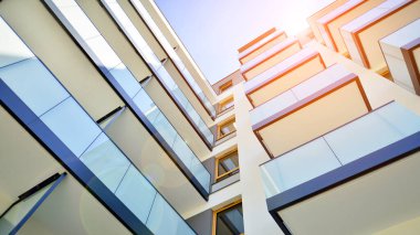 Modern apartman binası. Konut mimarisine yenilikçi bir yaklaşım. Gökyüzünde gün ışığı parlıyor.