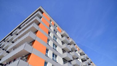 Parlak yüzlü apartman dairesi. Bir sürü kare cam pencere ve balkonu olan modern minimalist mimari.