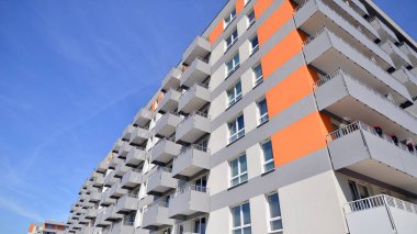 Parlak yüzlü apartman dairesi. Bir sürü kare cam pencere ve balkonu olan modern minimalist mimari.