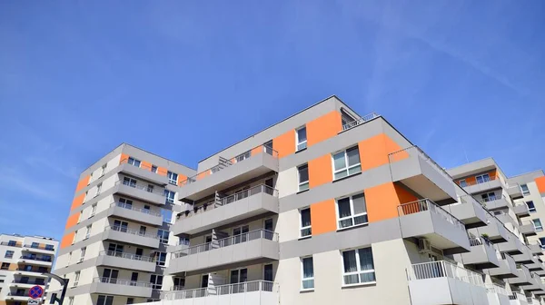 Apartment building with bright facades. Modern minimalist architecture with lots of square glass windows and balconies.