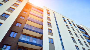 Apartman, ev ve dış görünüş mimarisi ve açık hava tesisleri. Arka planda mavi gökyüzü. Gün doğumunda gün ışığı.