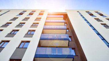 Apartman, ev ve dış görünüş mimarisi ve açık hava tesisleri. Arka planda mavi gökyüzü. Gün doğumunda gün ışığı.