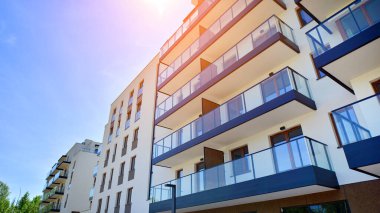 Apartman, ev ve dış görünüş mimarisi ve açık hava tesisleri. Arka planda mavi gökyüzü. Gün doğumunda gün ışığı.