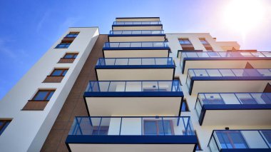 Apartman, ev ve dış görünüş mimarisi ve açık hava tesisleri. Arka planda mavi gökyüzü. Gün doğumunda gün ışığı.