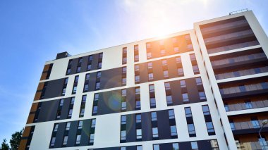 Apartman, ev ve dış görünüş mimarisi ve açık hava tesisleri. Arka planda mavi gökyüzü. Gün doğumunda gün ışığı.