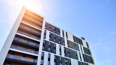 Apartman, ev ve dış görünüş mimarisi ve açık hava tesisleri. Arka planda mavi gökyüzü. Gün doğumunda gün ışığı.