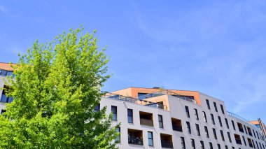 Ekolojik konut mimarisi. Ağaçların çevresindeki modern bir yerleşim yeri. Ekoloji ve yeşil yaşam şehirde, kentsel çevre kavramı. Modern apartman ve yeşil ağaçlar.