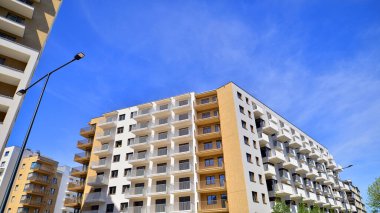 Modern lüks konut dairesi. Güneşli bir günde modern apartman binası. Mavi gökyüzü olan bir apartman. Modern bir apartmanın cephesi.