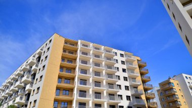 Modern lüks konut dairesi. Güneşli bir günde modern apartman binası. Mavi gökyüzü olan bir apartman. Modern bir apartmanın cephesi.