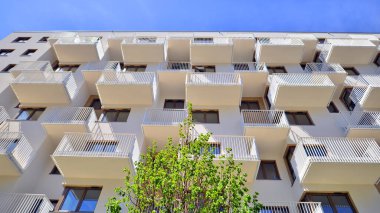 Ekolojik konut mimarisi. Ağaçların çevresindeki modern bir yerleşim yeri. Ekoloji ve yeşil yaşam şehirde, kentsel çevre kavramı. Modern apartman ve yeşil ağaçlar.
