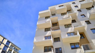 Modern lüks konut dairesi. Güneşli bir günde modern apartman binası. Mavi gökyüzü olan bir apartman. Modern bir apartmanın cephesi.