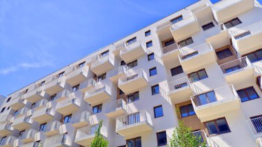 Modern lüks konut dairesi. Güneşli bir günde modern apartman binası. Mavi gökyüzü olan bir apartman. Modern bir apartmanın cephesi.