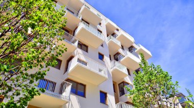 Ekolojik konut mimarisi. Ağaçların çevresindeki modern bir yerleşim yeri. Ekoloji ve yeşil yaşam şehirde, kentsel çevre kavramı. Modern apartman ve yeşil ağaçlar.