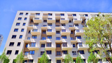 Ekolojik konut mimarisi. Ağaçların çevresindeki modern bir yerleşim yeri. Ekoloji ve yeşil yaşam şehirde, kentsel çevre kavramı. Modern apartman ve yeşil ağaçlar.