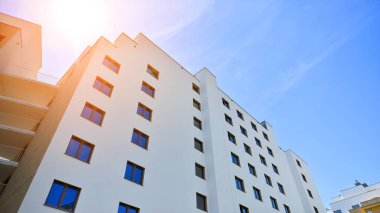 Apartman, ev ve dış görünüş mimarisi ve açık hava tesisleri. Arka planda mavi gökyüzü. Gün doğumunda gün ışığı.