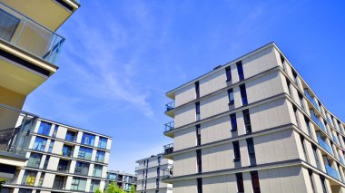 Modern lüks konut dairesi. Güneşli bir günde modern apartman binası. Mavi gökyüzü olan bir apartman. Modern bir apartmanın cephesi.