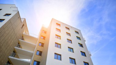 Apartman, ev ve dış görünüş mimarisi ve açık hava tesisleri. Arka planda mavi gökyüzü. Gün doğumunda gün ışığı.