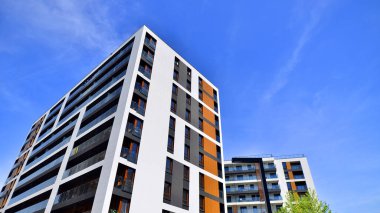 Modern lüks konut dairesi. Güneşli bir günde modern apartman binası. Mavi gökyüzü olan bir apartman. Modern bir apartmanın cephesi.