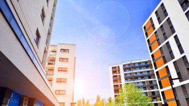 Ekolojik konut mimarisi. Ağaçların çevresindeki modern bir yerleşim yeri. Ekoloji ve yeşil yaşam şehirde, kentsel çevre kavramı. Modern apartman ve yeşil ağaçlar.