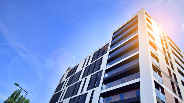 Архитектура фасадов жилых домов и домов, наружные сооружения. Голубое небо на фоне. Солнечный свет на рассвете.