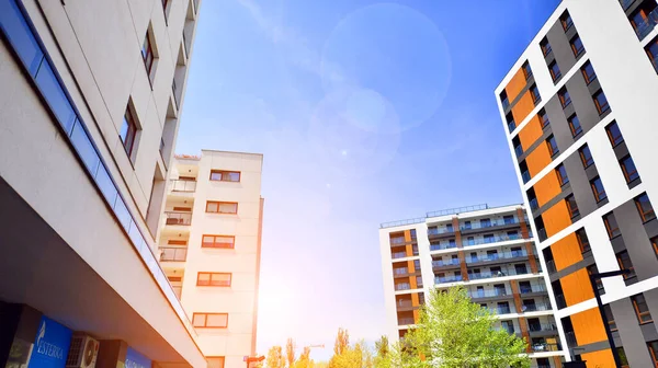 Ecological housing architecture. A modern residential building in the vicinity of trees. Ecology and green living in city, urban environment concept. Modern apartment building and green trees.