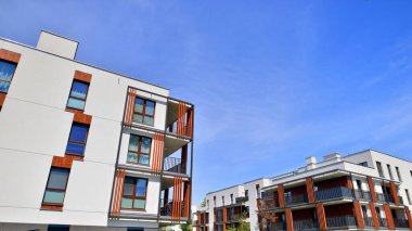 Modern lüks konut dairesi. Güneşli bir günde modern apartman binası. Mavi gökyüzü olan bir apartman. Modern bir apartmanın cephesi.