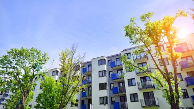 Ekolojik konut mimarisi. Ağaçların çevresindeki modern bir yerleşim yeri. Ekoloji ve yeşil yaşam şehirde, kentsel çevre kavramı. Modern apartman ve yeşil ağaçlar.