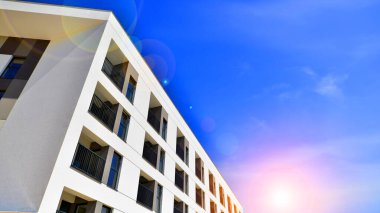 Apartman, ev ve dış görünüş mimarisi ve açık hava tesisleri. Arka planda mavi gökyüzü. Gün doğumunda gün ışığı.