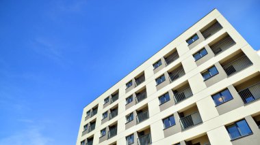 Apartman, ev ve dış görünüş mimarisi ve açık hava tesisleri. Arka planda mavi gökyüzü. Gün doğumunda gün ışığı.