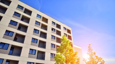 Ekolojik konut mimarisi. Ağaçların çevresindeki modern bir yerleşim yeri. Ekoloji ve yeşil yaşam şehirde, kentsel çevre kavramı. Modern apartman ve yeşil ağaçlar.