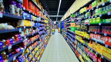 Varşova, Polonya. 15 Haziran 2022. Süpermarket koridoru rafları dolduran ürünlerle dolu. Carrefour süpermarketi.