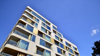 Modern lüks konut dairesi. Güneşli bir günde modern apartman binası. Mavi gökyüzü olan bir apartman. Modern bir apartmanın cephesi.