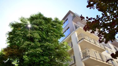 Modern lüks konut dairesi. Güneşli bir günde modern apartman binası. Mavi gökyüzü olan bir apartman. Modern bir apartmanın cephesi.