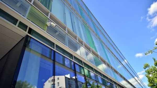 蓝色的天空映衬着现代的玻璃立面 商业区一幢建筑物的最底层视图 办公大楼玻璃立面的低角度视图 — 图库照片