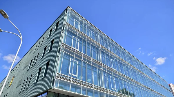 Modern glass facade against blue sky. Bottom view of a  building in the business district. Low angle view of the glass facade of an office building.