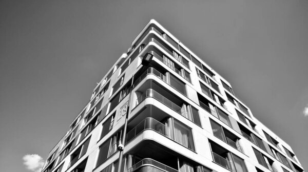 Fragment of modern residential apartment with flat buildings exterior. Detail of new luxury house and home complex. Black and white.