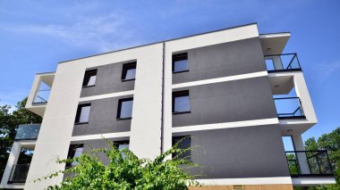 Modern lüks konut dairesi. Güneşli bir günde modern apartman binası. Mavi gökyüzü olan bir apartman. Modern bir apartmanın cephesi.