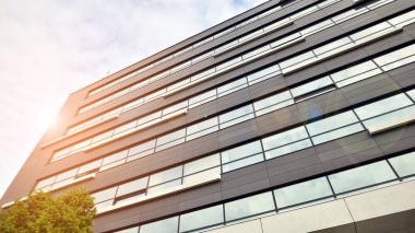 Glass and aluminum facade of a modern office building. View of futuristic architecture. Office building with cloud reflection on windows