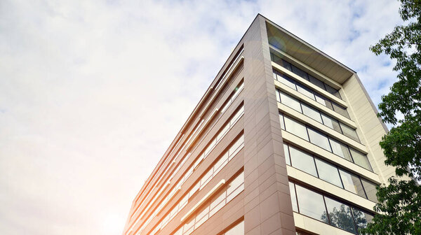 Стеклянный и алюминиевый фасад современного офисного здания. Вид на футуристическую архитектуру. Офисное здание с отражением облаков на окнах