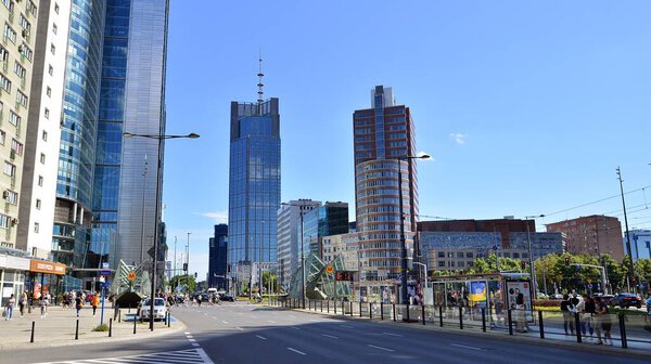 Warsaw, Poland. 14 July 2022. Road traffic in the city, public utility buildings and office buildings. Sunny day and cars on the road.