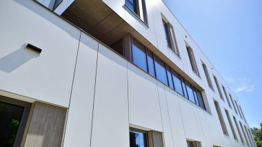 Beyaz alüminyum kompozit panelli ofis binası. Cam ve metalden yapılmış ön duvar. Soyut modern iş mimarisi.