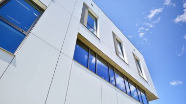 Beyaz alüminyum kompozit panelli ofis binası. Cam ve metalden yapılmış ön duvar. Soyut modern iş mimarisi.