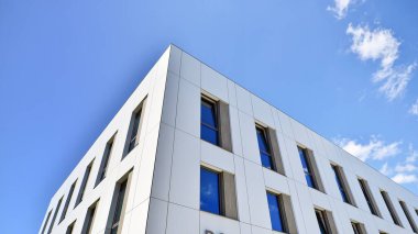 Beyaz alüminyum kompozit panelli ofis binası. Cam ve metalden yapılmış ön duvar. Soyut modern iş mimarisi.